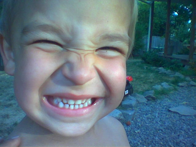 a little boy laughing with his teeth missing