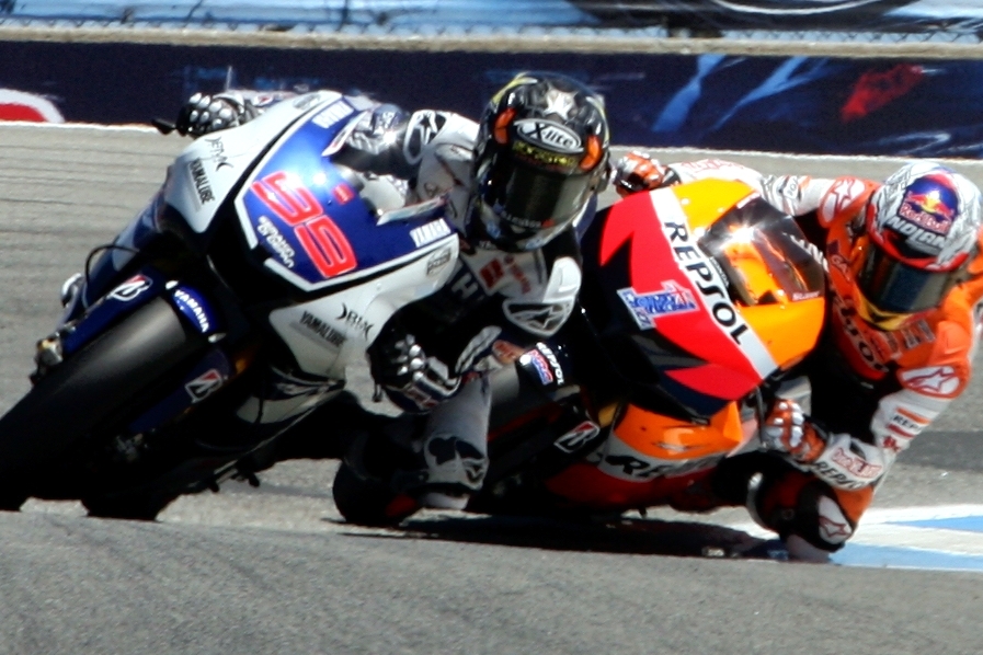 two motorcycle riders are riding a racing track