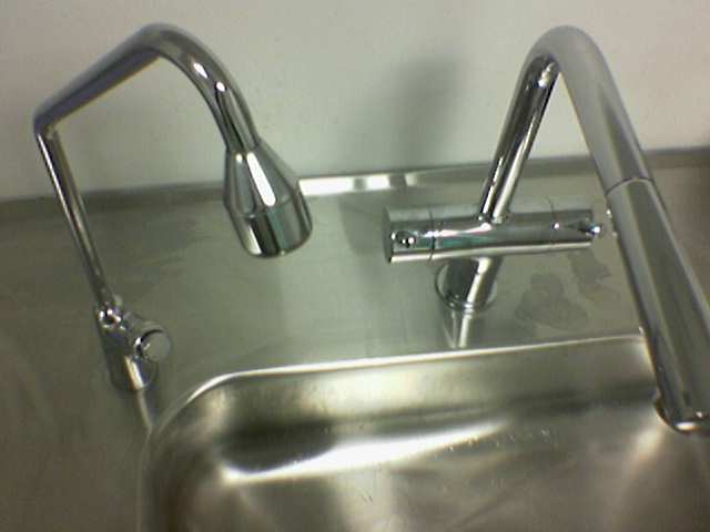 a chrome sink with handrails for handles