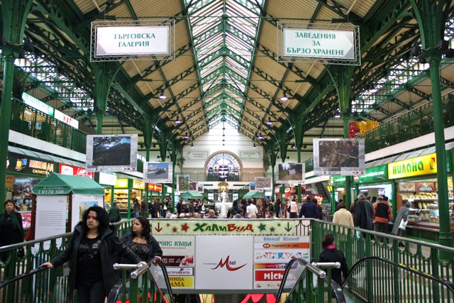 an indoor market with a metal bicycle in the middle