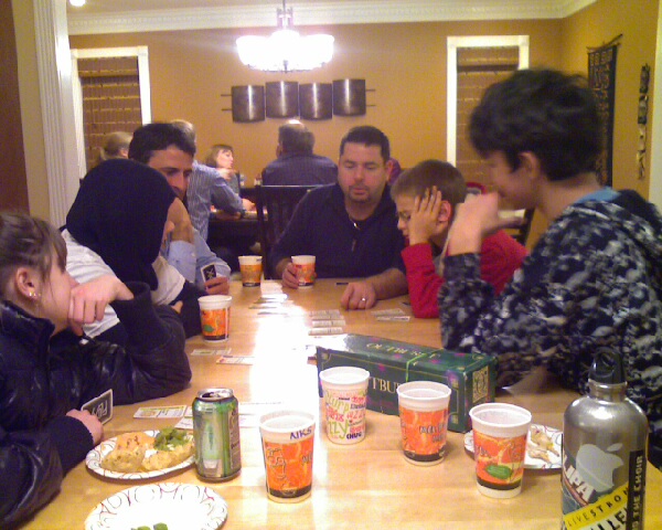 several people sitting at a table together enjoying food
