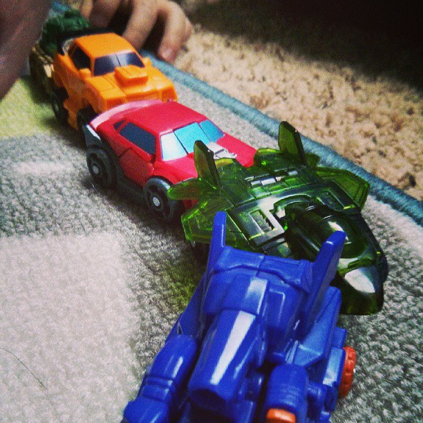 two toy cars and two people on carpet
