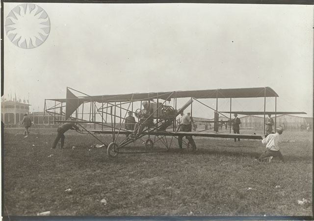 an old po of men working on a small airplane