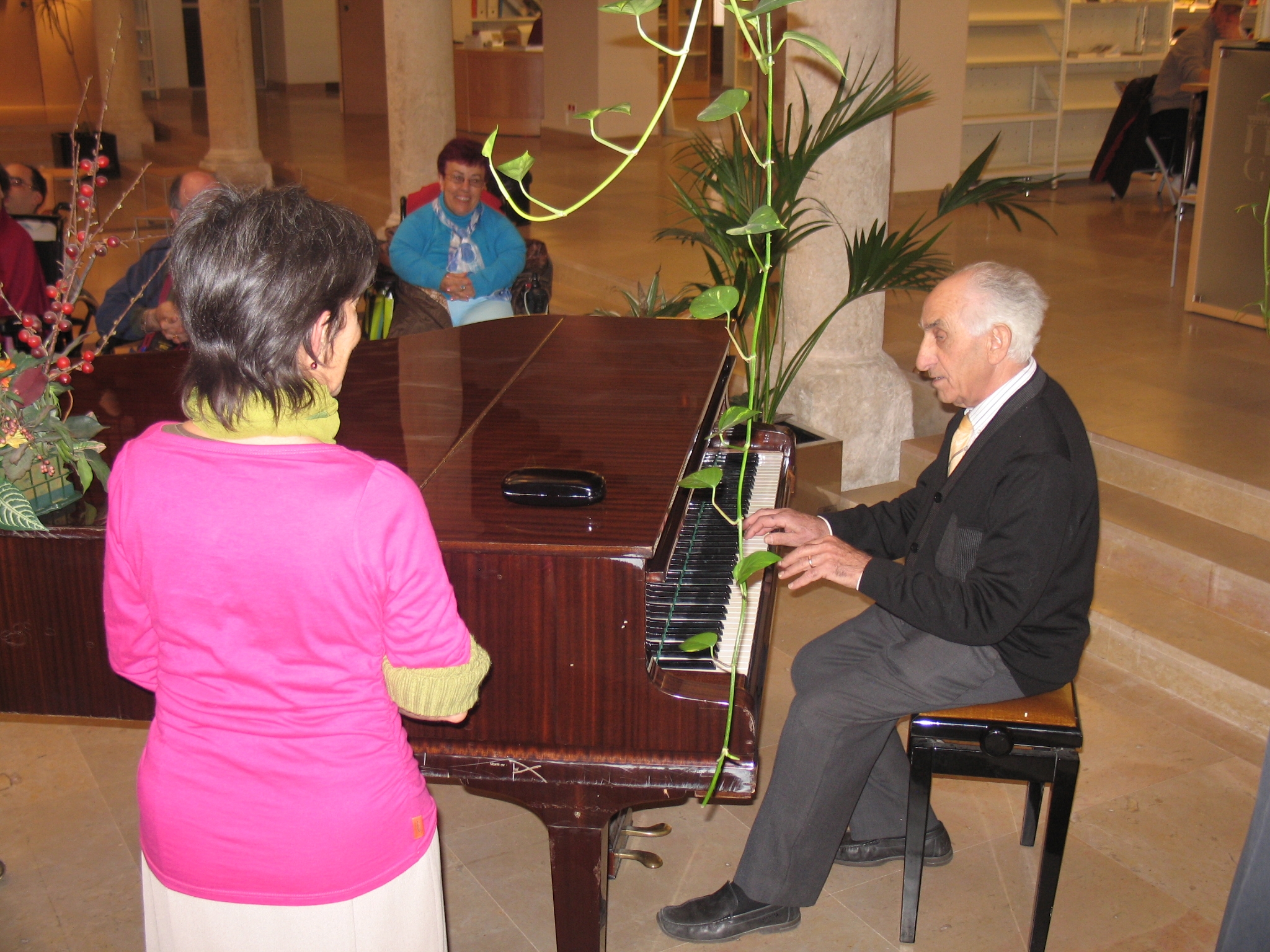 a man and woman sit at a piano