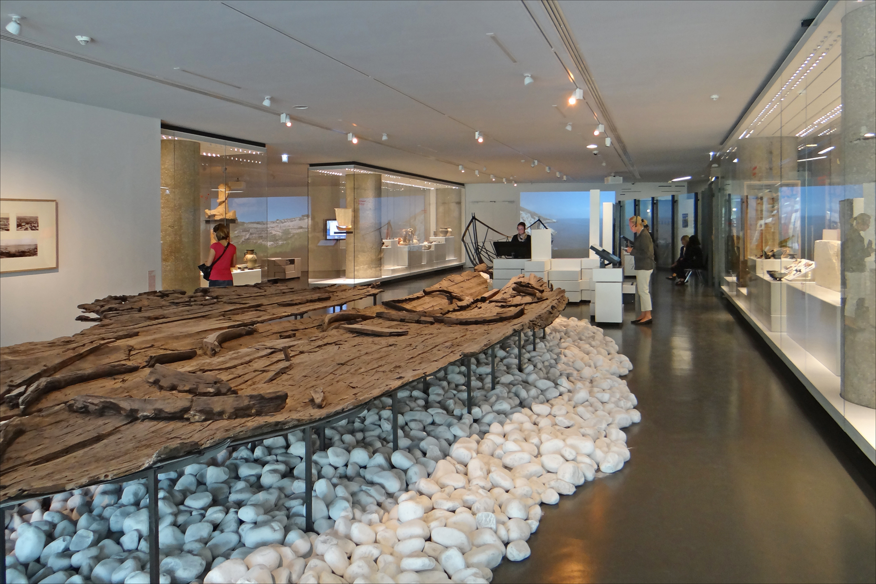 an elaborately carved boat sitting on display with people walking around it