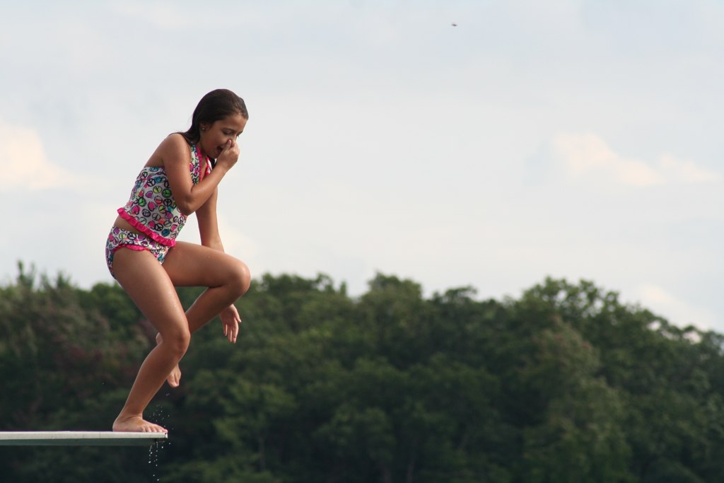 a girl is standing on top of a swimming board