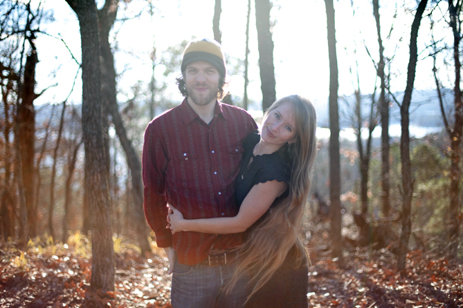 a young couple are posing for a picture in a field