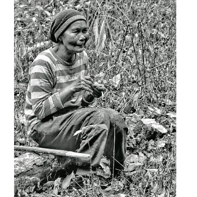 black and white pograph of an old man crouching down