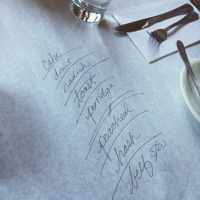 a close up of handwriting on a table with utensils