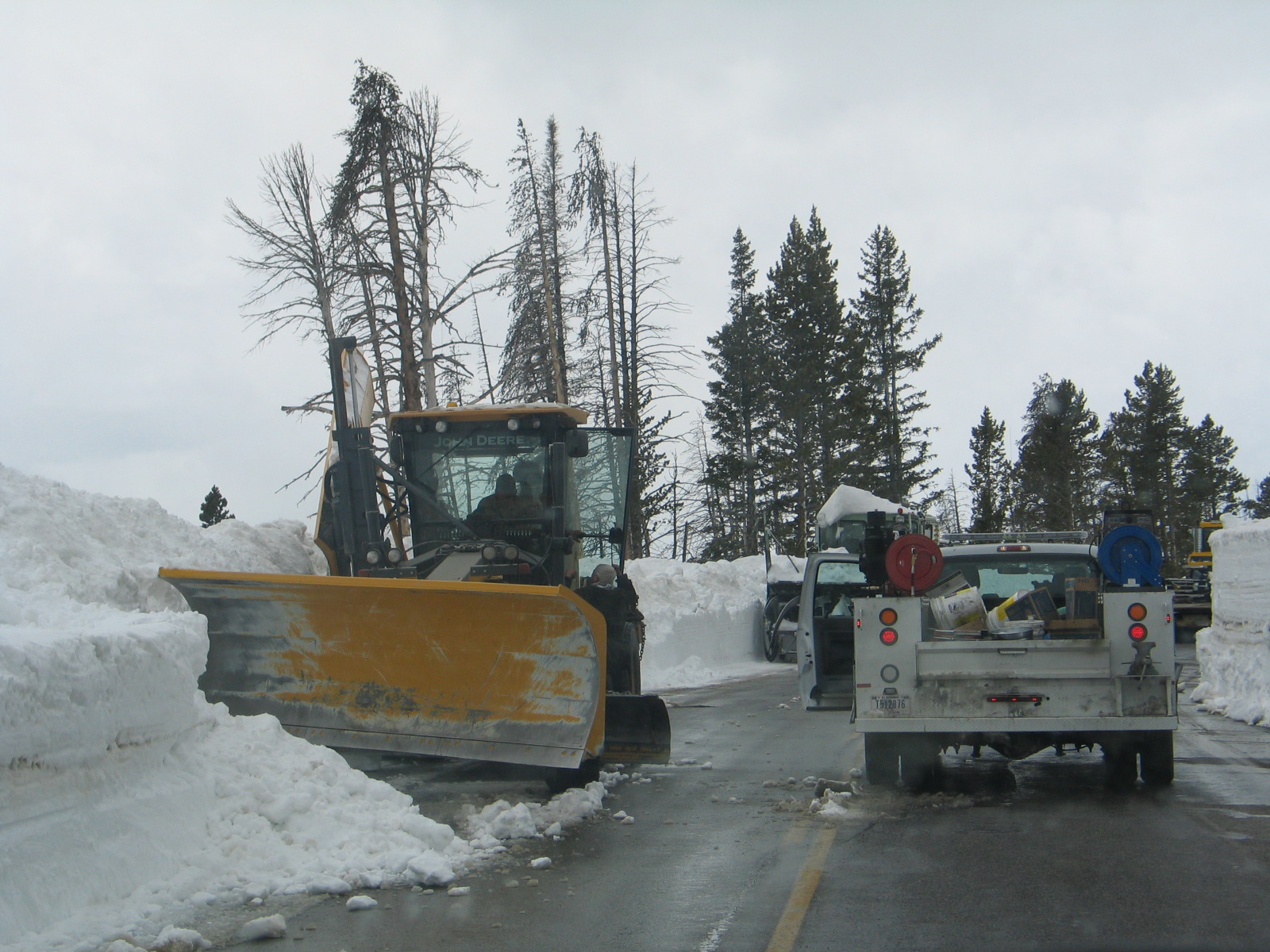 a snow plow and a truck on the road
