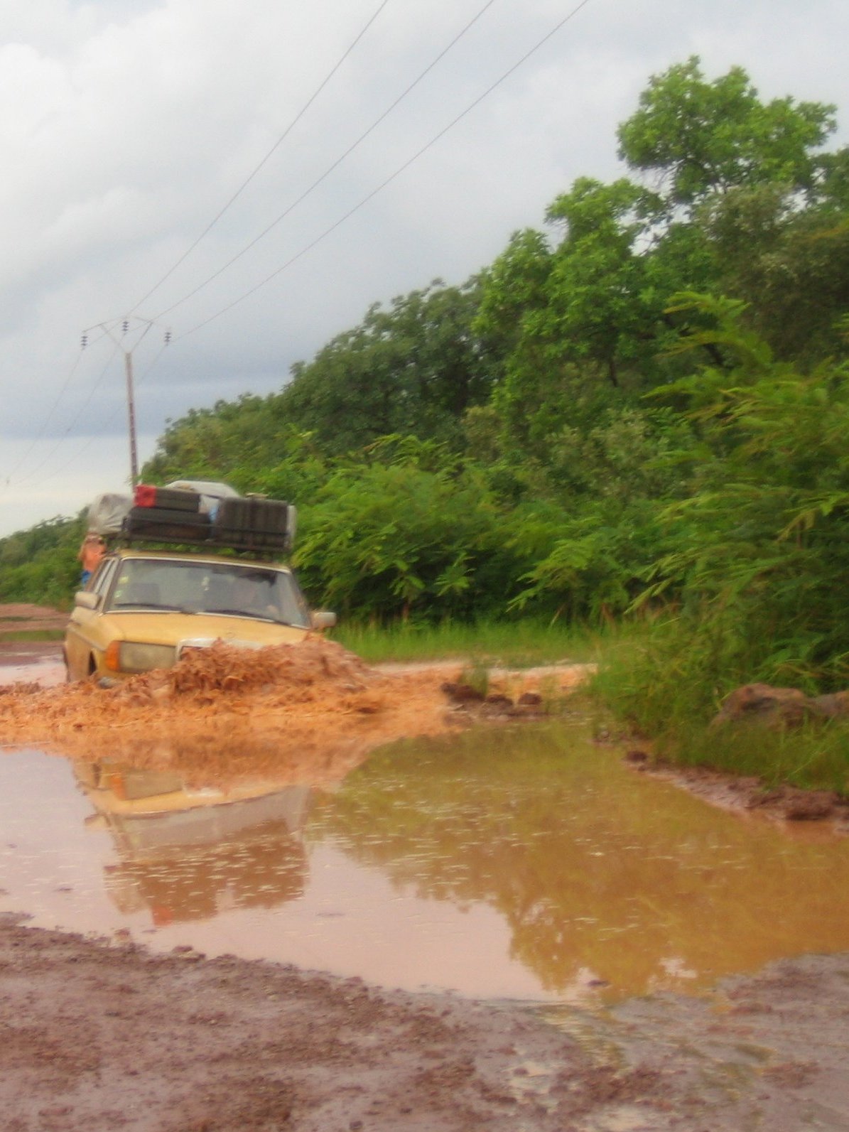 cars driving through muddy roads on over flowing water