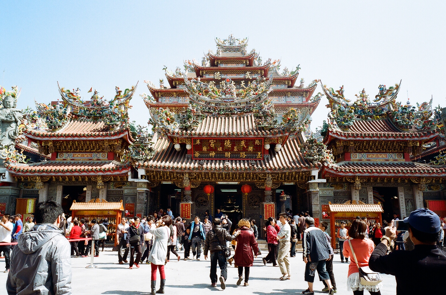 a group of people standing in front of an asian temple