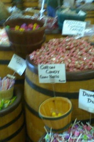 barrels with different types of candies are displayed in the store