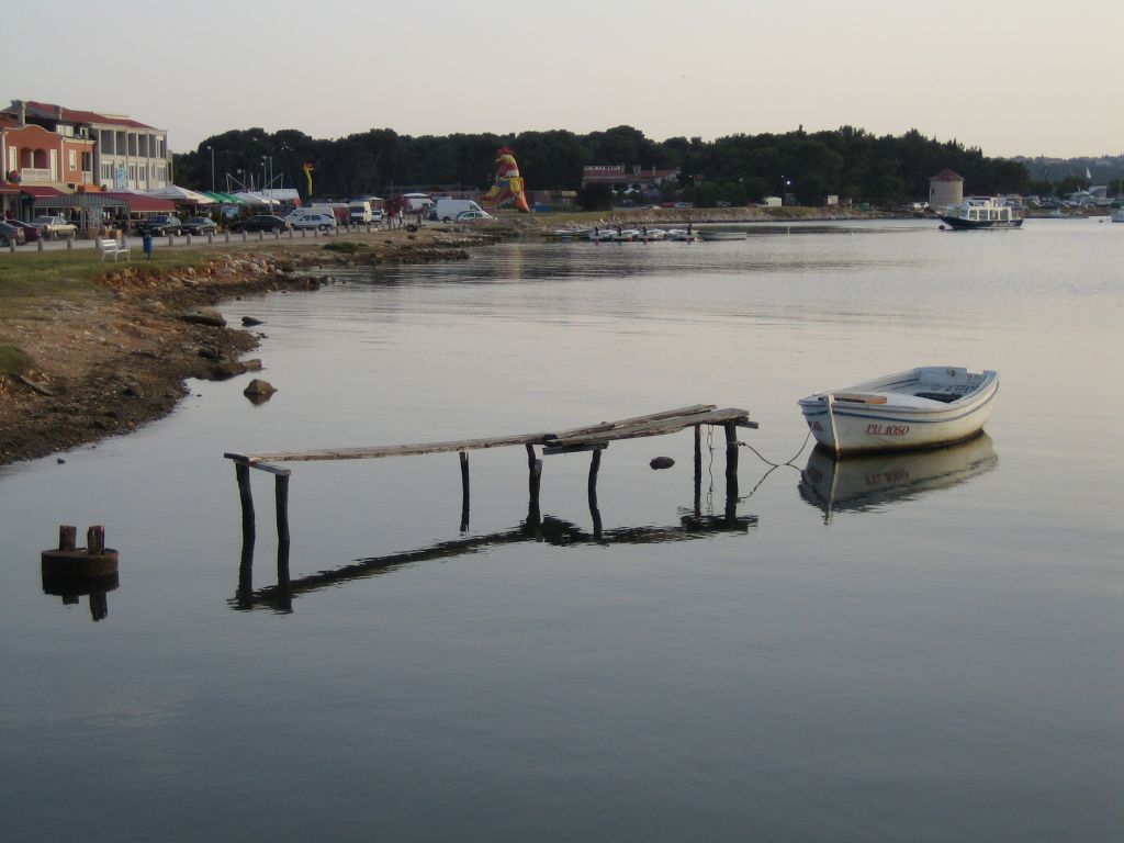 a white boat docked in the water at a dock