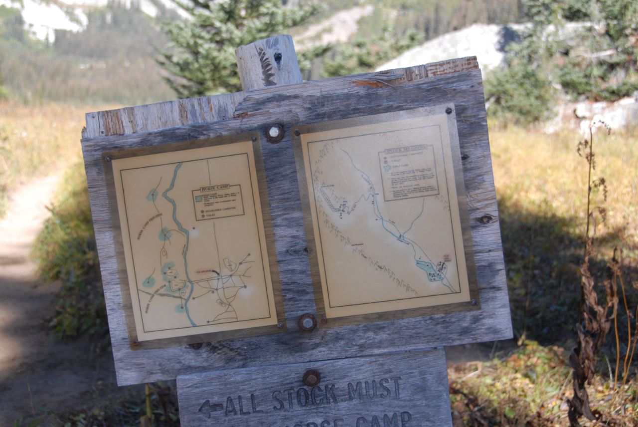 a map on a board that is standing on a trail
