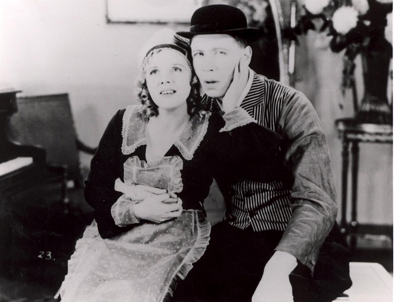 a young couple are seated in front of a piano