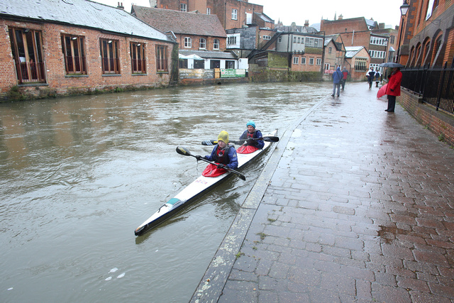 two people on a canoe paddling down the canal
