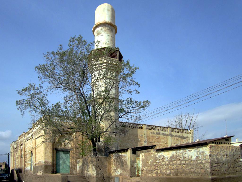 a tall structure with a tree in front of it