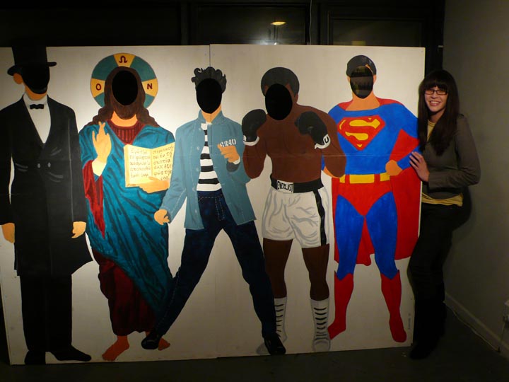 a group of three people stand in front of large paintings