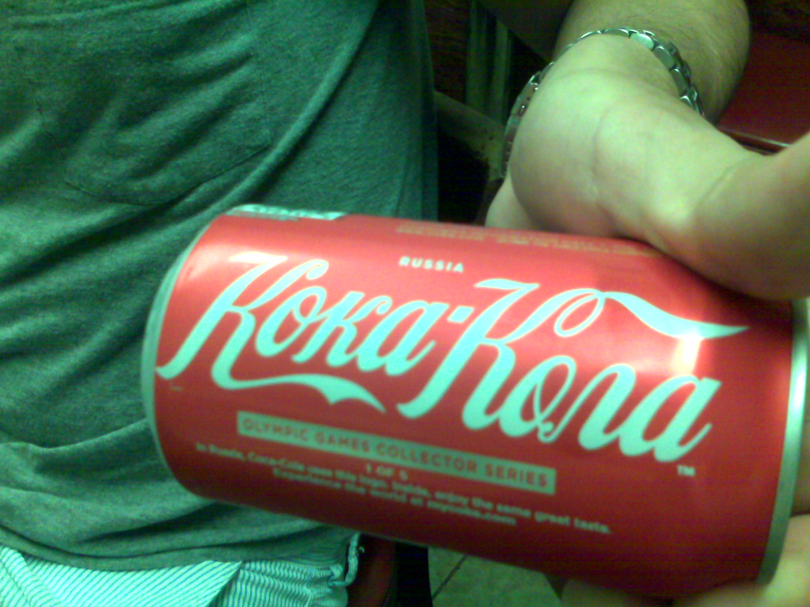 a hand holding a can of coca - cola