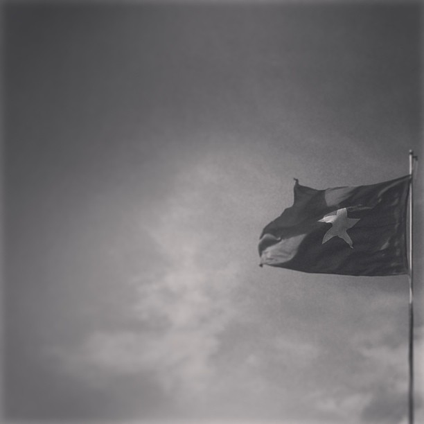 a flag flying on a windy day in the day