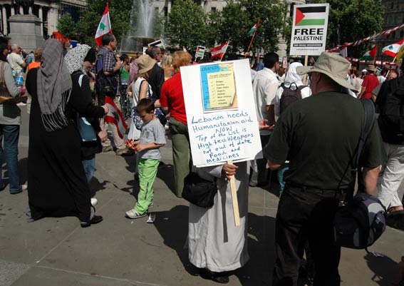 a man in a costume holding up a sign and standing on the sidewalk