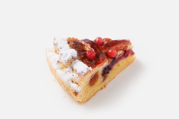 pastry with powdered sugar and pomegranate on white background