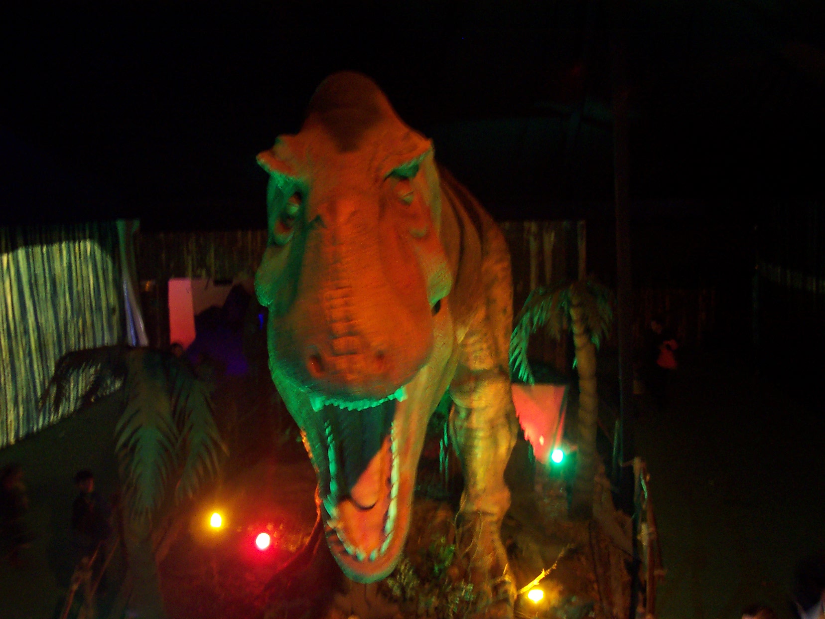 a dinosaur exhibit with people standing around the elephant