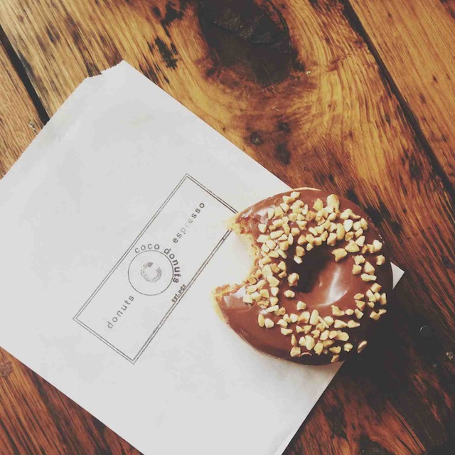 a chocolate doughnut with sprinkles on top of a napkin