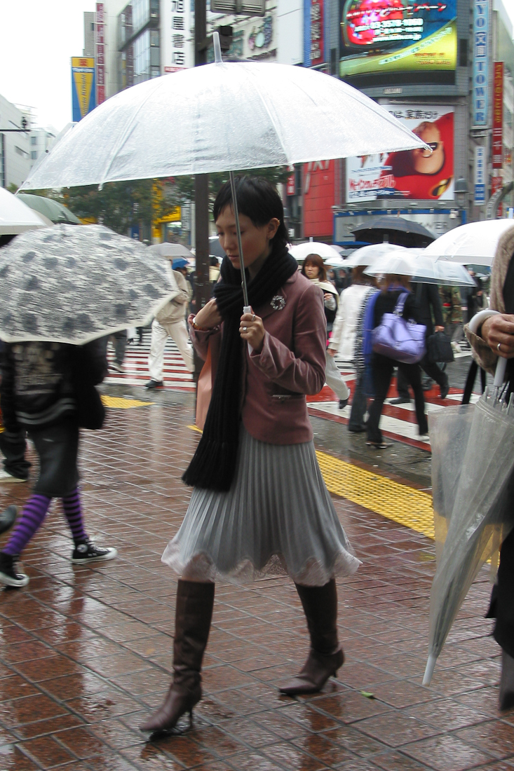 two women walking in the rain with umbrellas