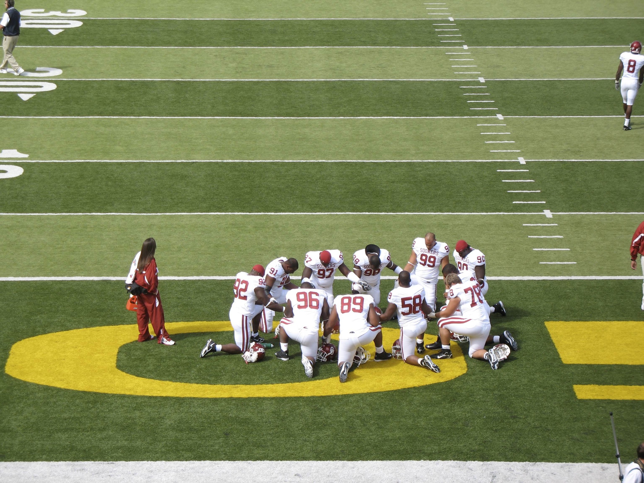 a team of football players huddle together on the field