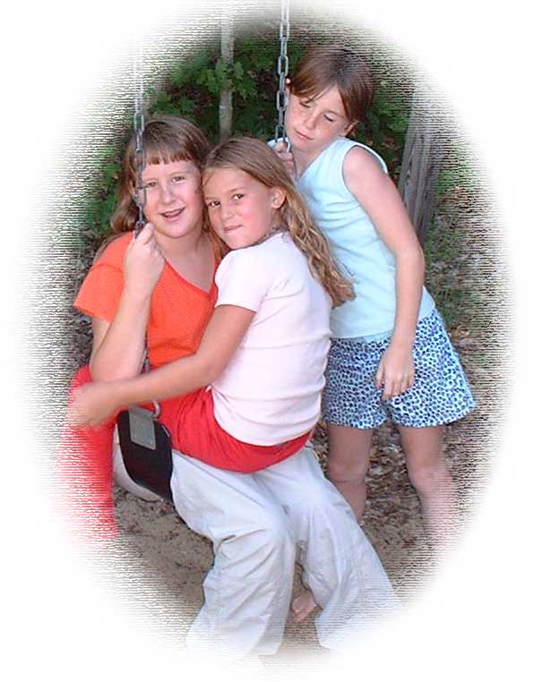 an image of three girls having fun on a swing