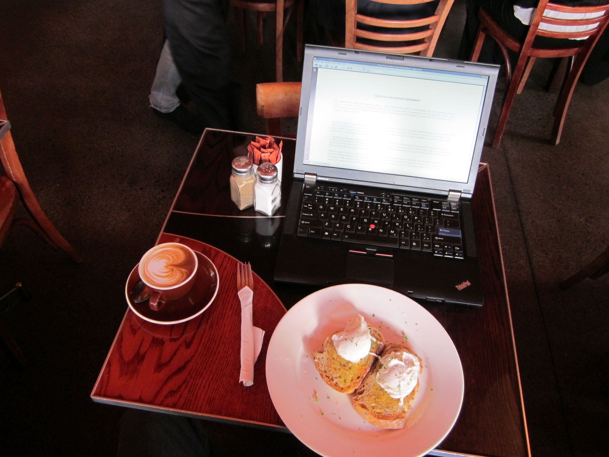 a cup of coffee and a plate of food sitting on top of a table