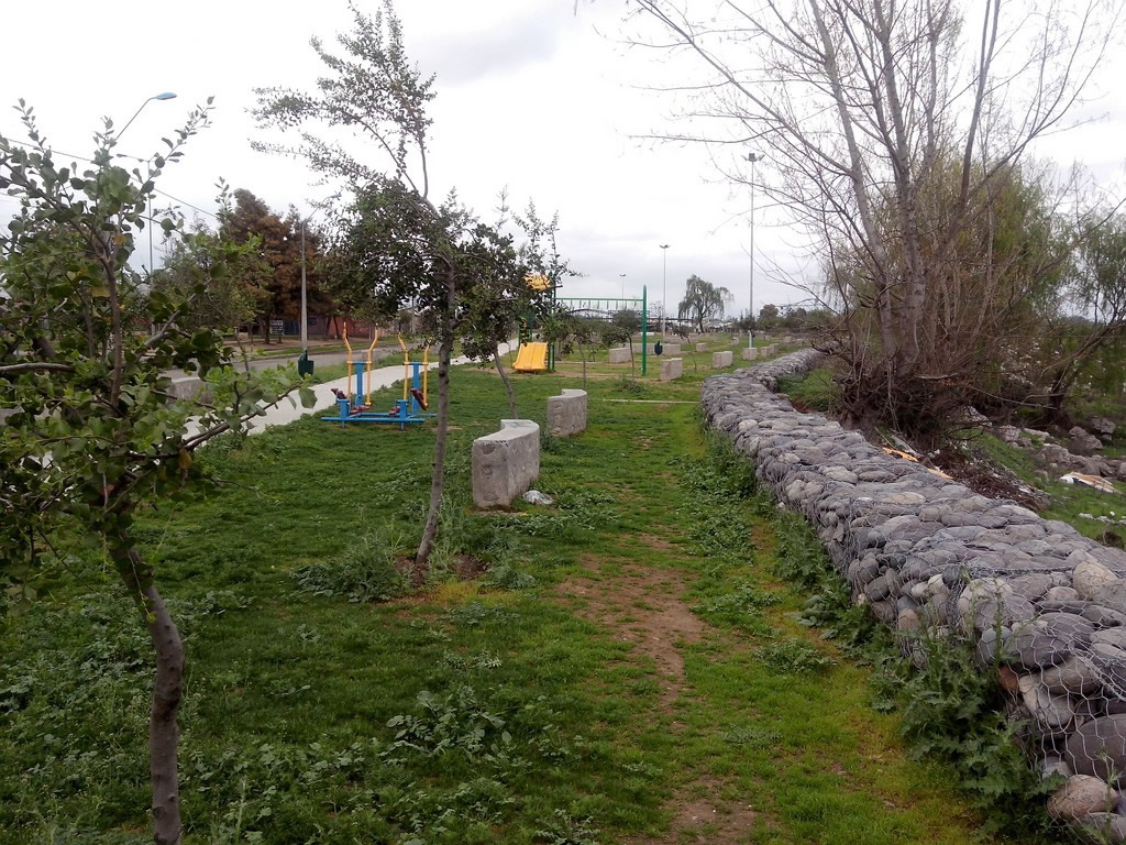 a stone wall and some benches in the grass