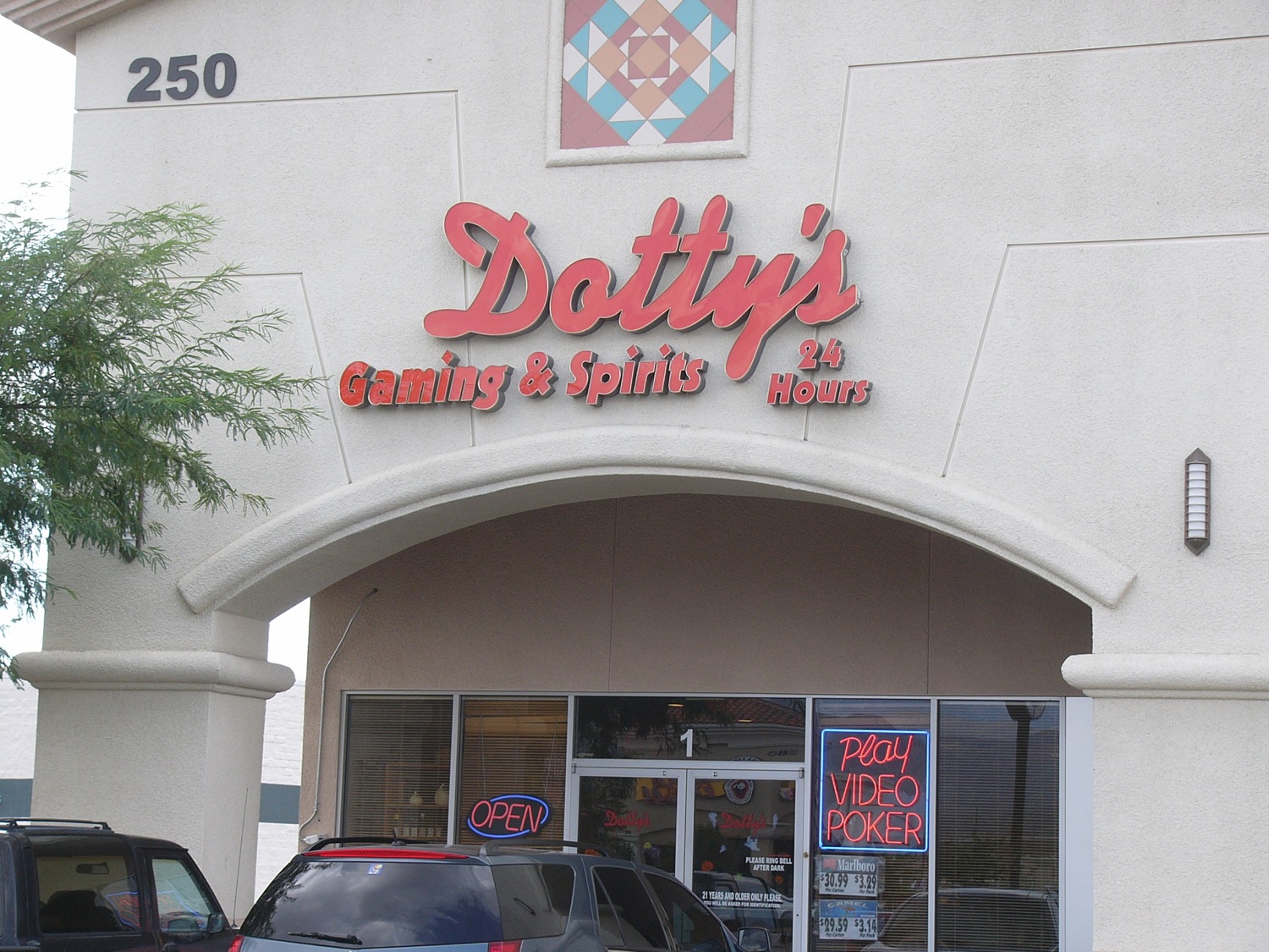 front entrance of doughnut shop with cars parked in front