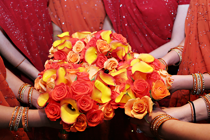 bridesmaid holding bright red, orange and yellow bouquet