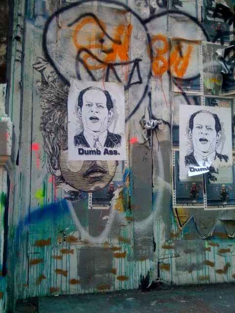 graffiti on a wall that has two political pictures