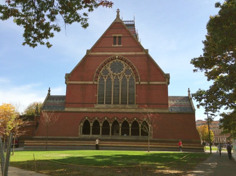 a red brick church sitting next to a tree
