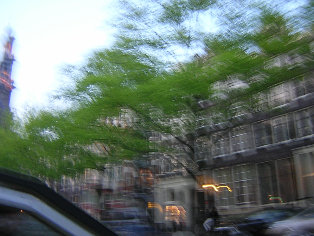 a blurry pograph of cars and a building with a tall steeple