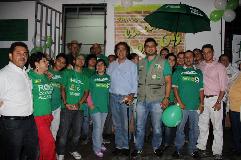 a group of people in green shirts with balls and a balloon