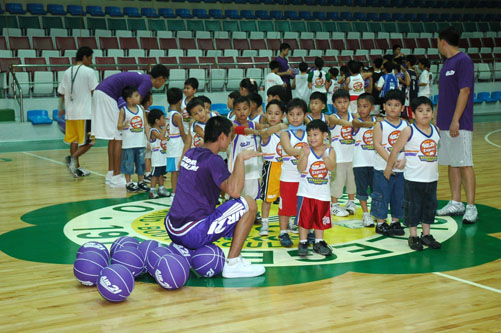 a man kneeling down in front of a group of small children