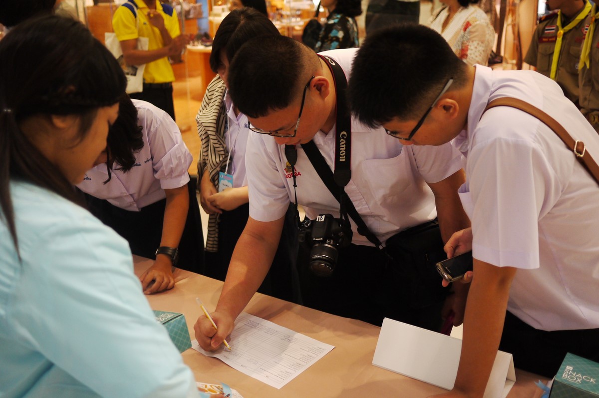 several people are standing over a table with some papers