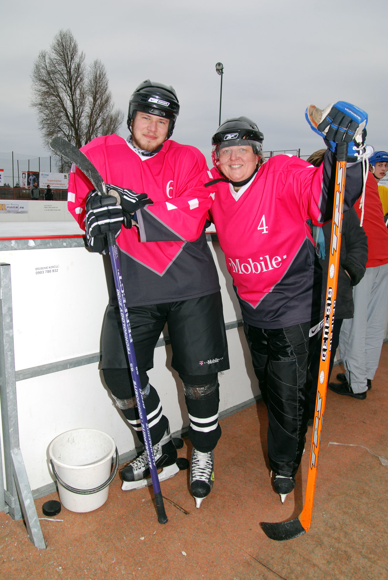 two people standing together next to each other wearing skiis and holding poles