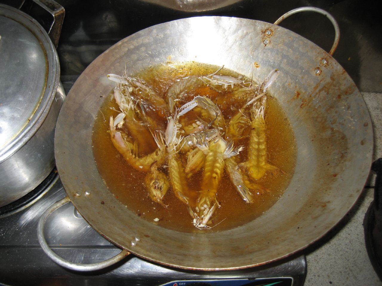 this is a bowl of cooked fish in sauce on a stove