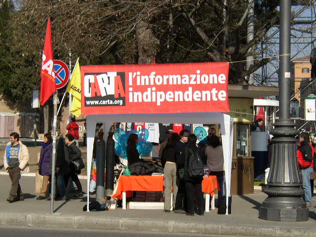 people stand around the tent selling information