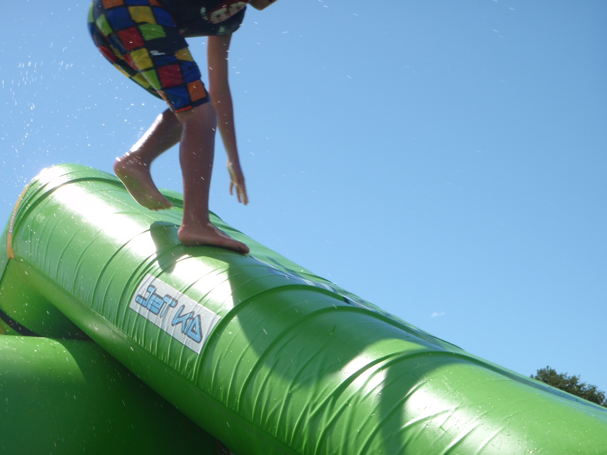 a person on a green slide near a blue sky