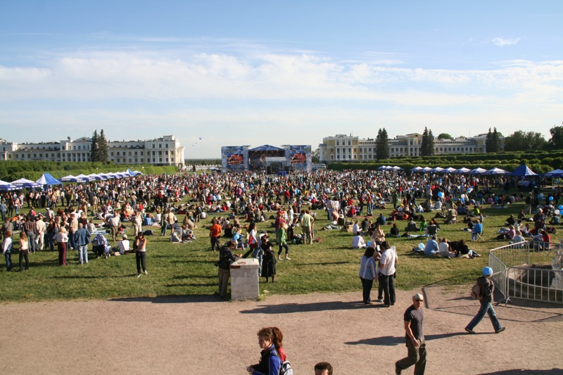 people gathered around in a grassy area near buildings