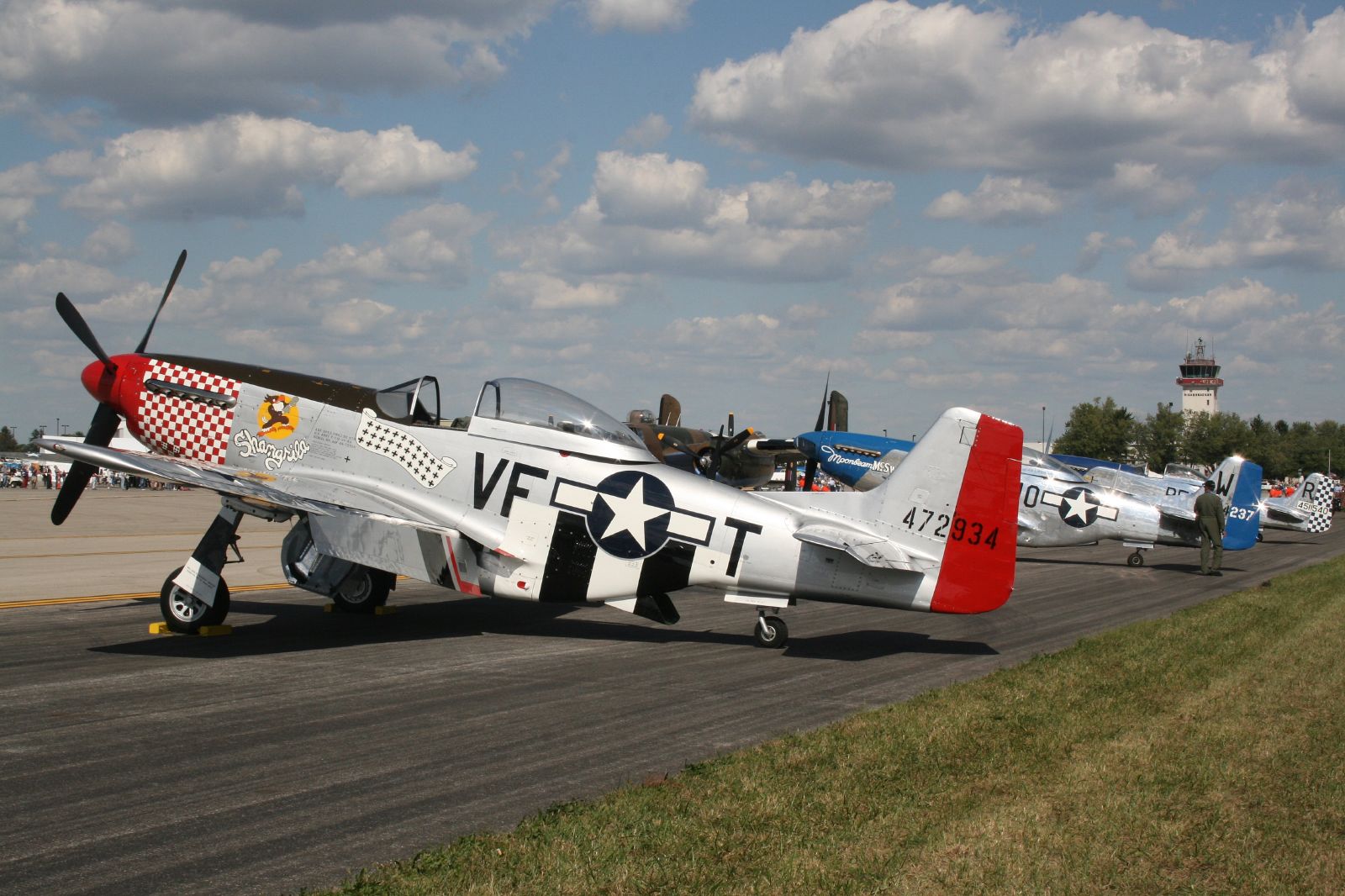 a group of vintage airplanes are parked on the runway