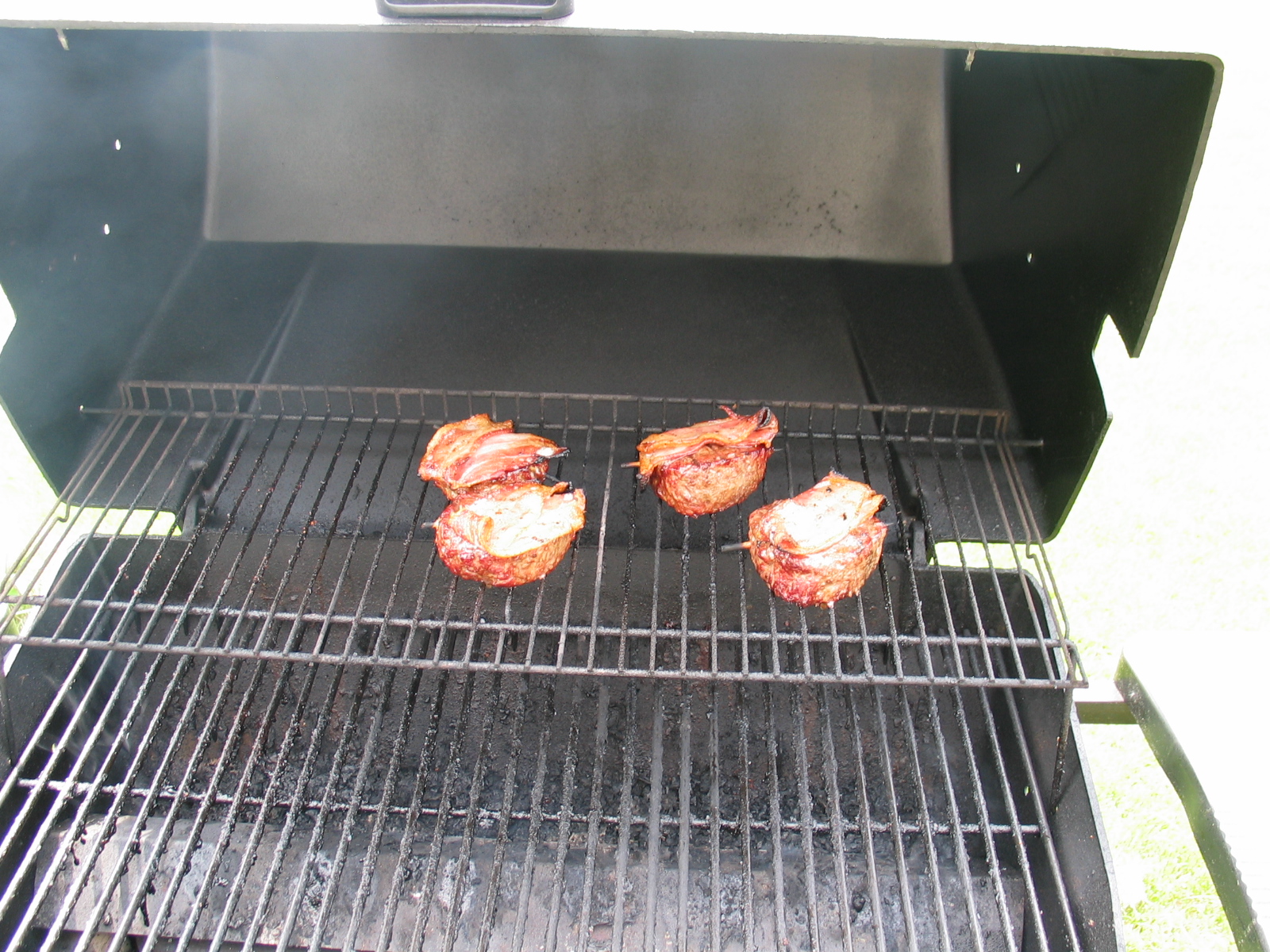 some food is cooking on an outdoor grill