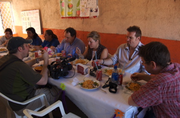 a group of people eating from plates at a table